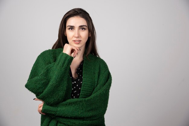 Portrait de femme en veste verte regardant la caméra.