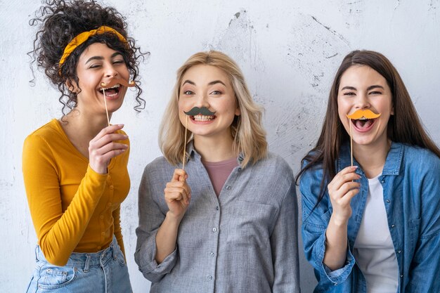 Portrait de femmes qui rient heureux avec des moustaches