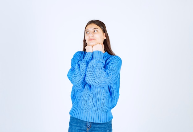 Portrait d'une fille adorable debout et posant sur blanc.