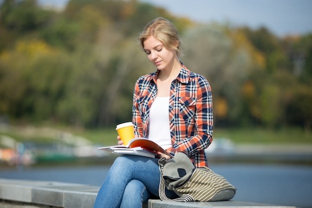 Photo gratuite portrait de fille assise à la lecture du pont