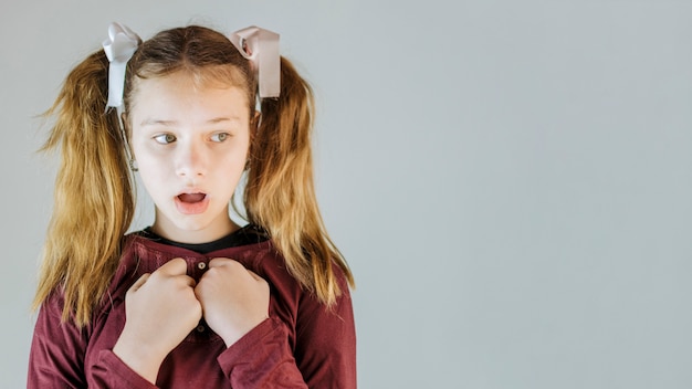 Portrait d&#39;une fille avec la bouche ouverte sur fond gris