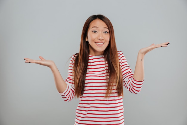 Portrait d'une fille drôle confuse, haussant les épaules