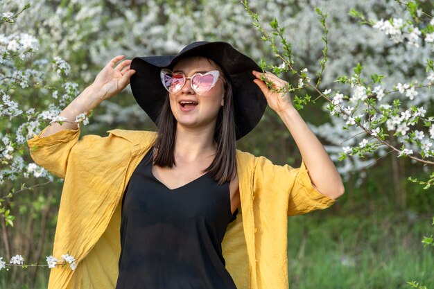 Portrait d'une fille élégante parmi les arbres en fleurs dans la forêt