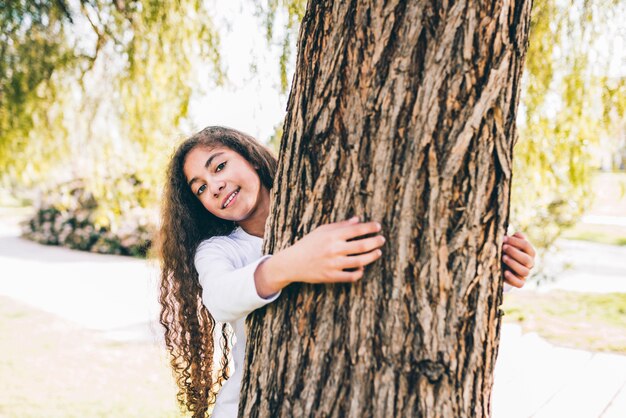 Portrait d&#39;une fille heureuse embrassant un grand coffre dans le jardin