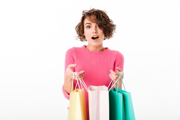 Portrait d'une fille heureuse excitée ouvre des sacs à provisions