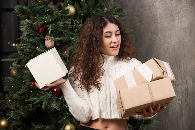 Portrait de fille heureuse regardant des cadeaux dans un emballage