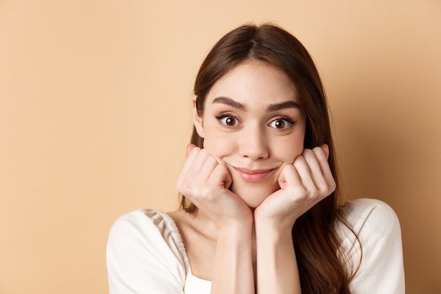 Portrait d'une fille intriguée écoutant avec intérêt et excitation entendre une histoire intéressante souriante am...