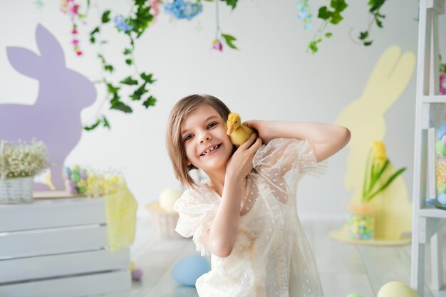 Portrait de fille joyeuse qui joue et communique avec les décorations de pâques canetons joyeuses pâques