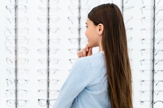 Portrait fille en magasin de lunettes en choisissant la paire