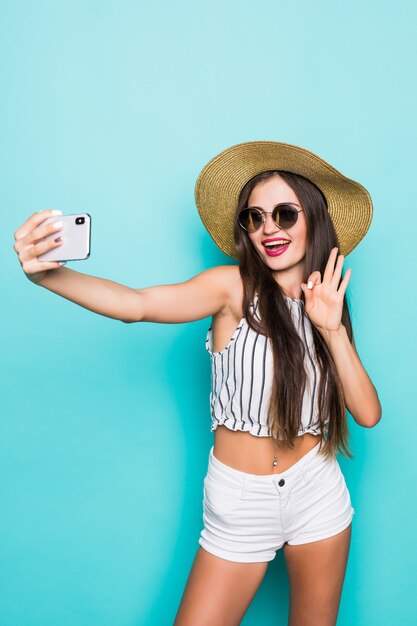 Portrait de fille de rêve faire blog selfie envoyer des baisers aériens à ses abonnés date en ligne isolée sur fond de couleur turquoise sarcelle