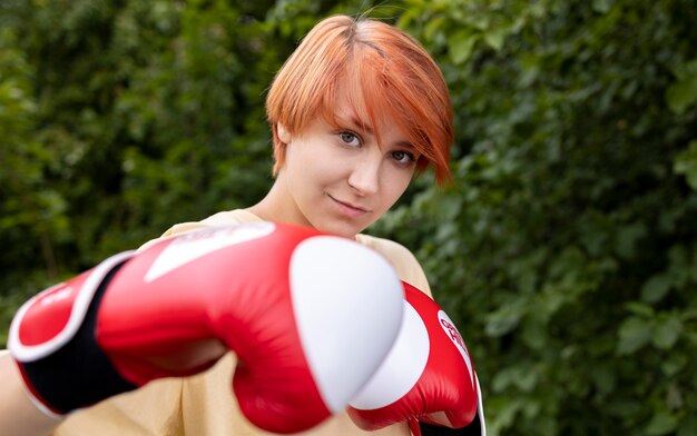 Portrait de fille rousse confiante avec des gants de boxe