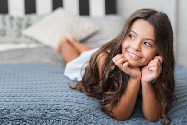 Portrait, de, fille souriante, coucher lit confortable