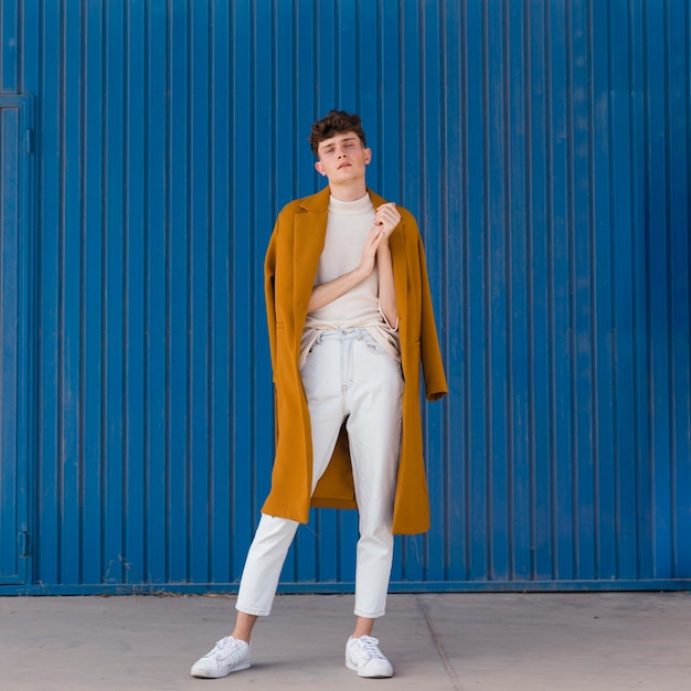 Portrait d'un garçon à la mode contre le mur bleu