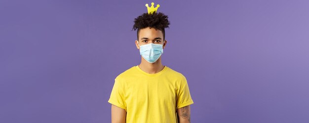 Portrait d'un gars hispanique drôle dans un masque facial qui s'amuse à devenir fou en restant à l'intérieur de la maison pendant quara