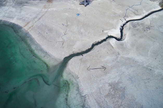 Portrait d'une grande fissure sur le rivage pierreux à côté de l'eau turquoise