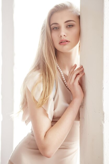 Portrait en gros plan d'une belle femme mince aux longs cheveux blonds et aux lèvres rouges.