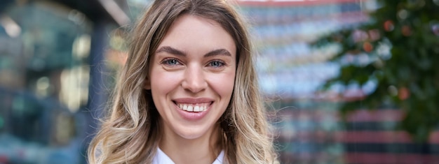 Photo gratuite portrait en gros plan d'une belle femme souriante, âgée de 20 ans, portant des vêtements d'entreprise, l'air heureuse