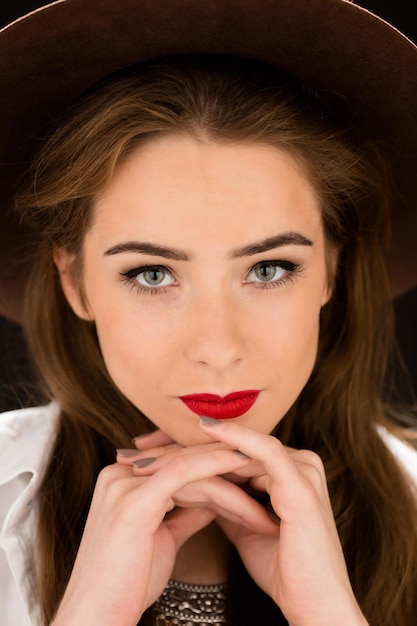 Photo gratuite portrait en gros plan d'une dame souriante aux lèvres rouges en regardant la caméra.