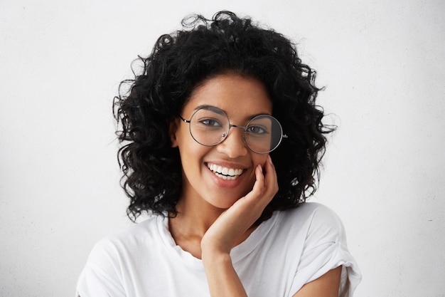 Portrait de gros plan d'une femme afro-américaine aux cheveux bouclés et touffus sombres portant des lunettes