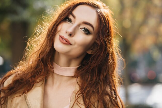 Portrait de gros plan d'une femme au gingembre intéressée avec de beaux yeux verts