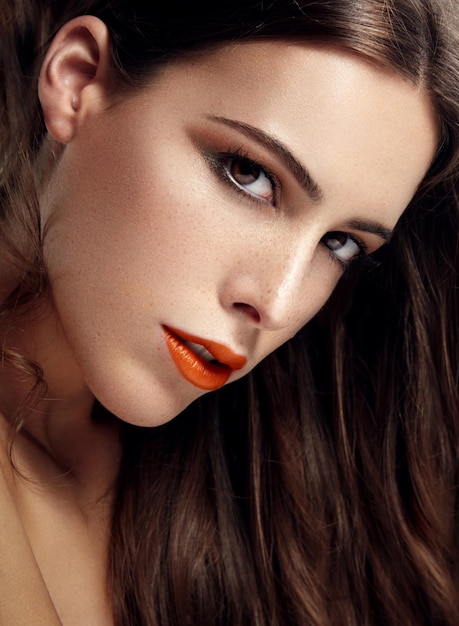 Portrait en gros plan d'une femme aux lèvres tendance orange