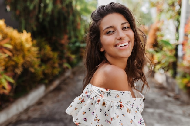 Portrait de gros plan de femme bronzée au repos en chemisier léger