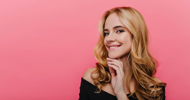 Portrait en gros plan d'une femme caucasienne joyeuse aux grands yeux bleus. Fille joyeuse romantique aux cheveux blonds posant avec un sourire heureux.