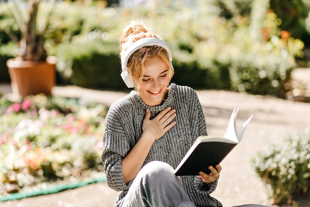 Portrait de gros plan de femme écoutant de la musique et lisant un livre