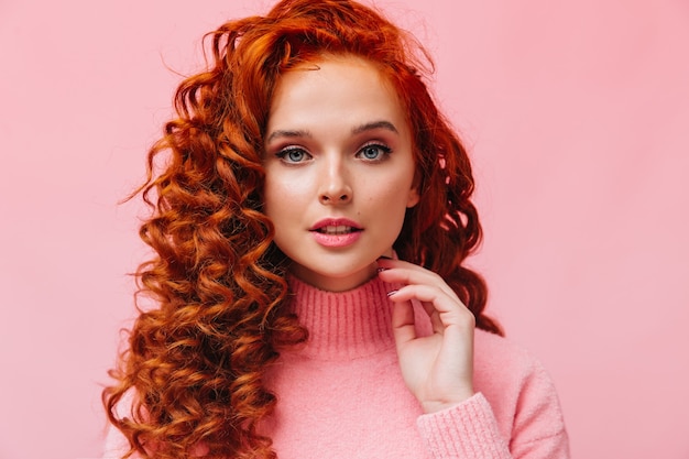 Portrait en gros plan d'une femme rousse bouclée aux yeux bleus