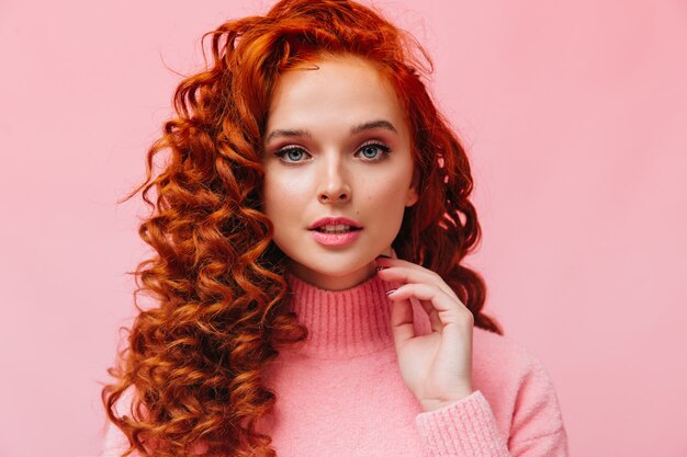 Portrait en gros plan d'une femme rousse bouclée aux yeux bleus