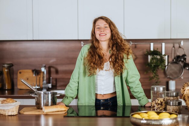 Portrait en gros plan d'une femme souriante heureuse dans la cuisine regardant directement la caméra