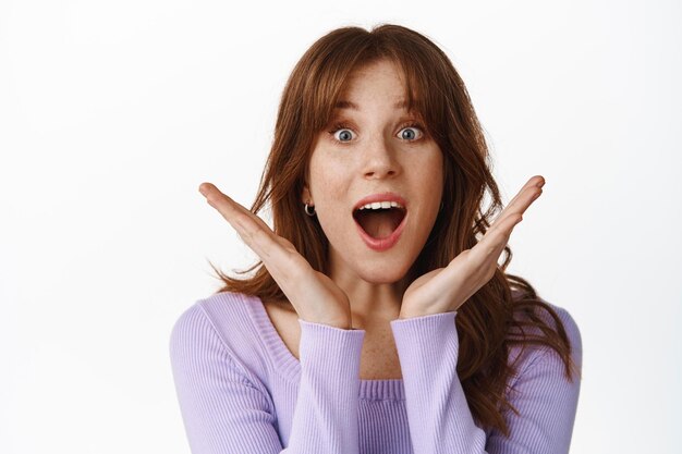 Portrait en gros plan d'une fille à la mode excitée et surprise, haletant, laissant tomber la mâchoire de l'étonnement, regardant une offre promotionnelle incroyable, écoutez de bonnes nouvelles, debout sur fond blanc