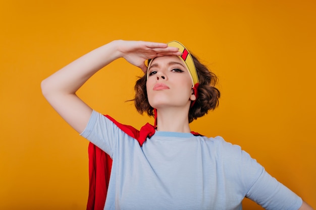 Photo gratuite portrait de gros plan de fille séduisante en chemise bleue debout dans une pose confiante sur l'espace jaune