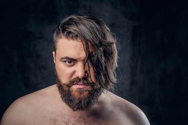 Photo gratuite portrait en gros plan d'un homme à barbe torse nu sur fond gris.