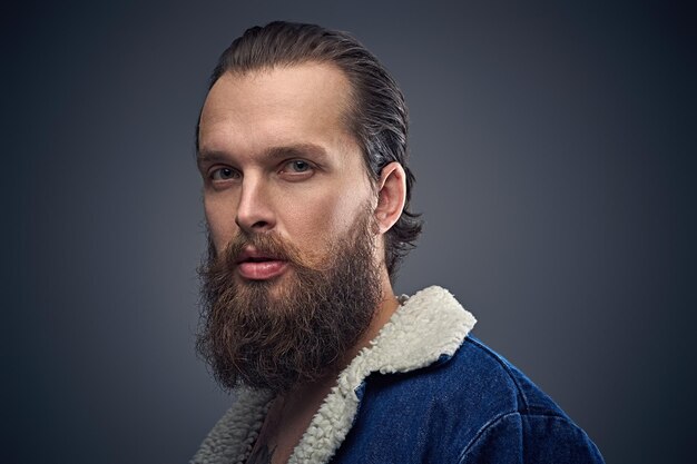 Portrait en gros plan d'un homme barbu sur fond gris vignette.