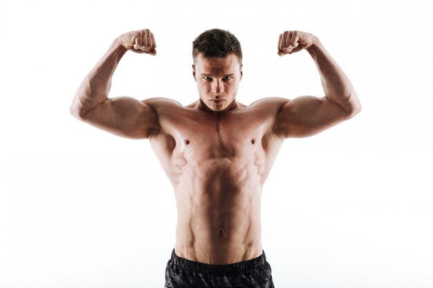 Portrait de gros plan de l'homme de sport fort en sueur montrant ses biceps