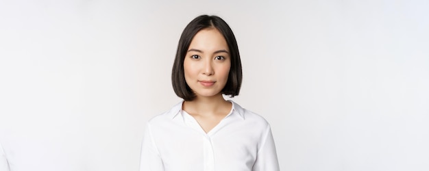 Portrait en gros plan d'une jeune femme asiatique coréenne professionnelle à la recherche de confiance et d'assurance à l'arrière-plan blanc de la caméra Concept de gens d'affaires