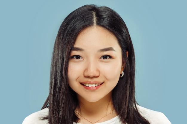 Portrait en gros plan de la jeune femme coréenne. Modèle féminin en chemise blanche. Souriant et l'air heureux. Concept d'émotions humaines, expression faciale. Vue de face.