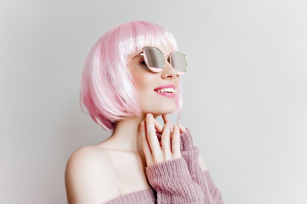 Portrait en gros plan d'une jeune fille à la mode intéressée au Pérou élégant. Photo intérieure de charmante femme charmante dans des lunettes de soleil scintillantes posant