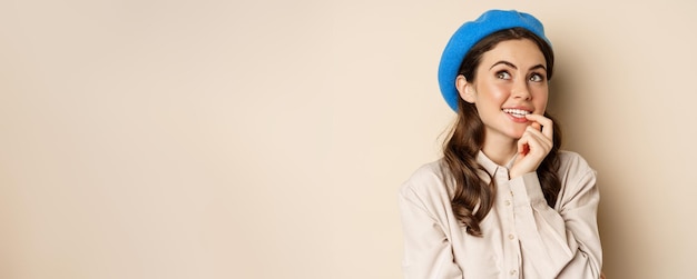 Photo gratuite portrait en gros plan d'une jeune fille souriante et rêveuse imaginant smth levant les yeux et pensant debout