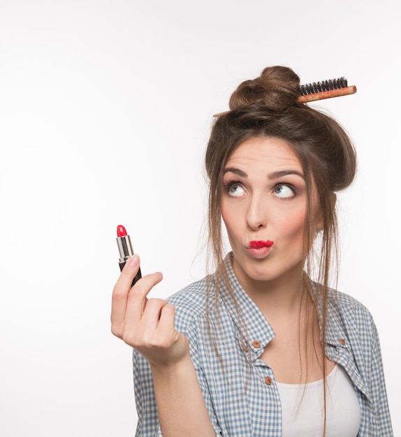 Portrait En Gros Plan D'une Jolie Femme Avec Une Coiffure Moderne Tenant Du Rouge à Lèvres Rouge Ou Rose Sur Blanc. Notion De Maquillage.