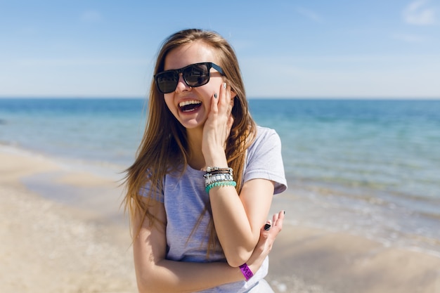 Portrait de gros plan d'une jolie jeune femme aux cheveux longs à la plage