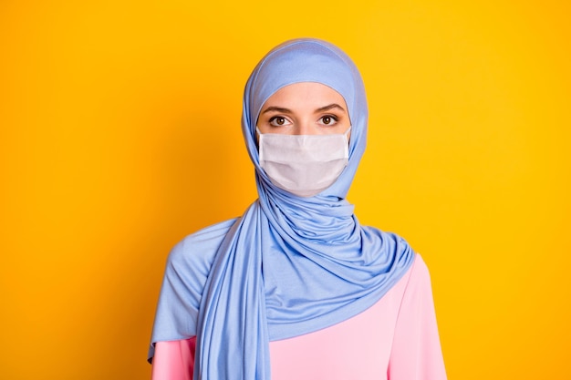 Portrait En Gros Plan D'un Muslimah Au Contenu Sérieux Et Attrayant Portant Un Masque Blanc Bleu Pastel Hijab Isolé Sur Fond De Couleur Jaune Vif Photo Premium