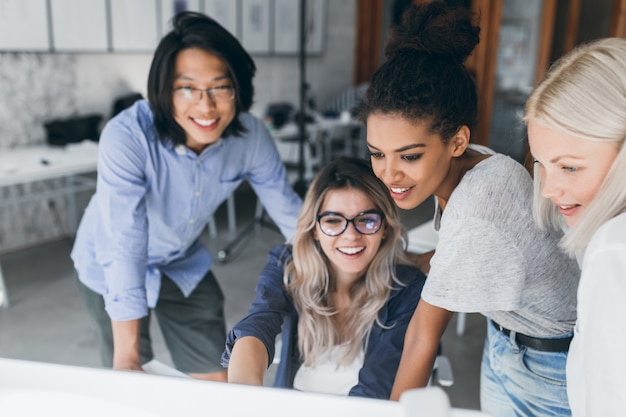 Portrait en gros plan de spécialistes en informatique indépendants regardant l'écran du portable avec le sourire