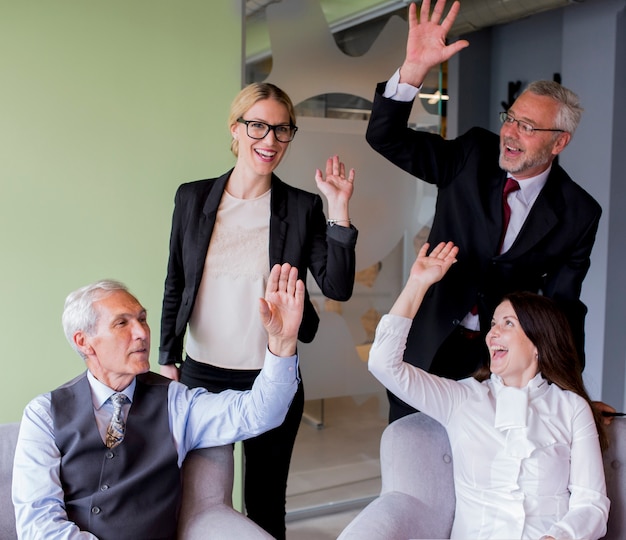 Photo gratuite portrait de groupe d'entreprises prospères agitant les mains au bureau