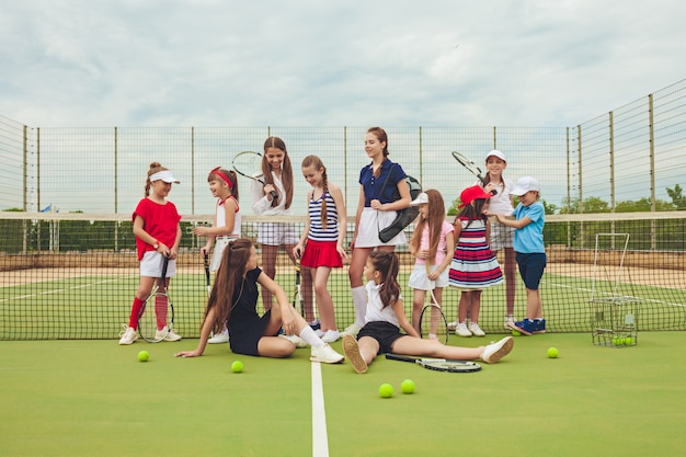 Portrait de groupe de filles en tant que joueurs de tennis tenant une raquette de tennis