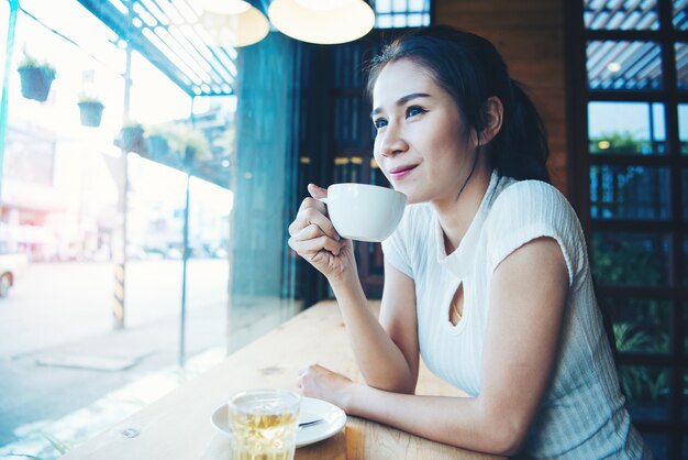 Portrait de heureuse belle femme avec une tasse dans les mains