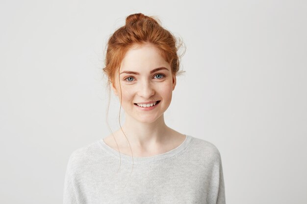 Portrait de heureuse fille tendre de gingembre aux yeux bleus et taches de rousseur souriant.