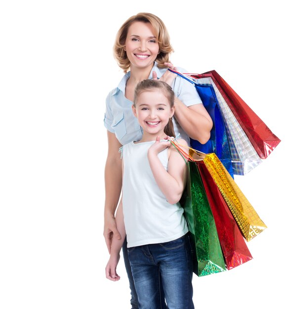 Portrait de l'heureuse mère blanche et jeune fille avec des sacs à provisions- isolé