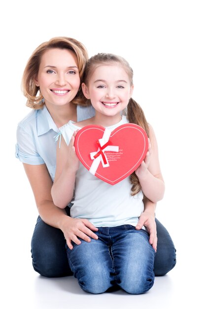 Portrait de l'heureuse mère et jeune fille tenir un cadeau pour anniversaire - isolé